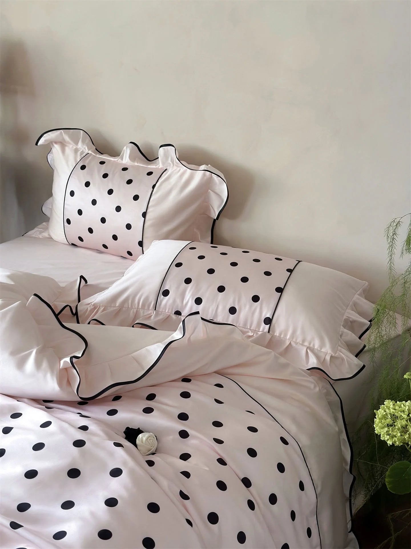 Close-up on the pillow shams of the Blush Pink & Black Polka Dot Tencel Bedding Set - RoomDen.