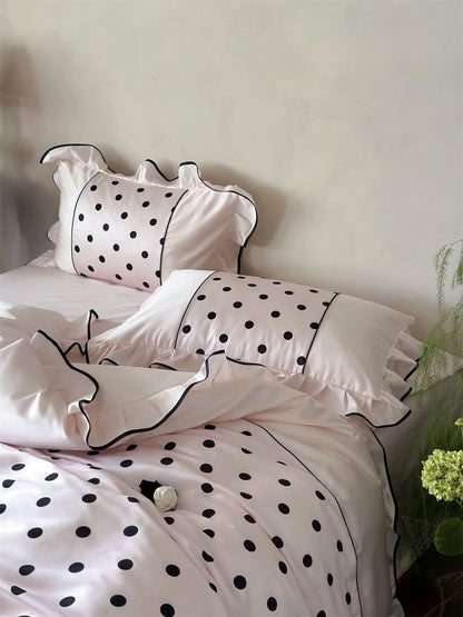 Close-up on the pillow shams of the Blush Pink & Black Polka Dot Tencel Bedding Set - RoomDen.