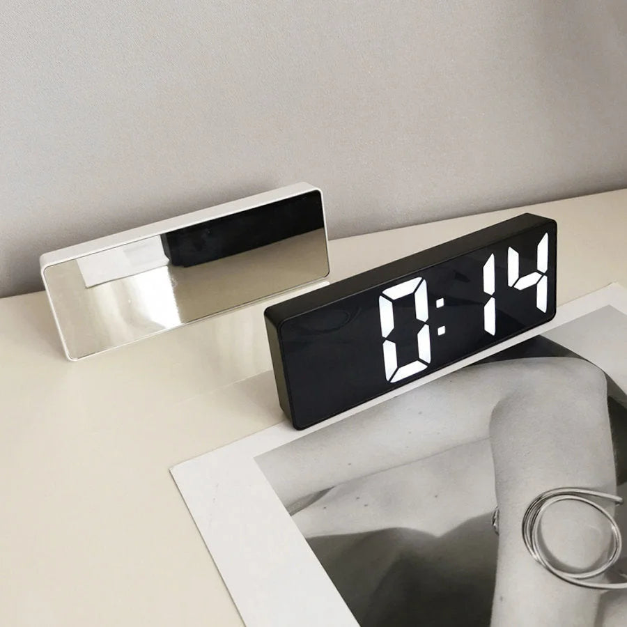 Side-by-side view of the black and white variants of the Mirrored Acrylic Digital Clock on a desk. - RoomDen