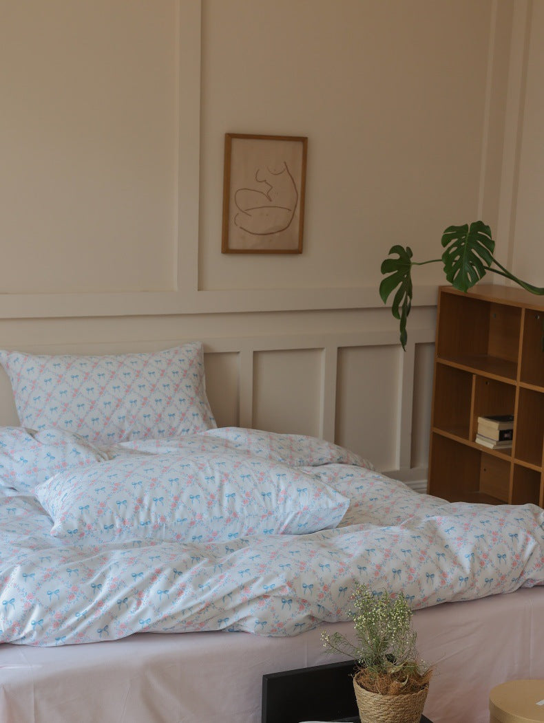 Ivory Blue Bow Rose Cotton Bedding Set – wide side view beside a wooden bookcase - Roomden