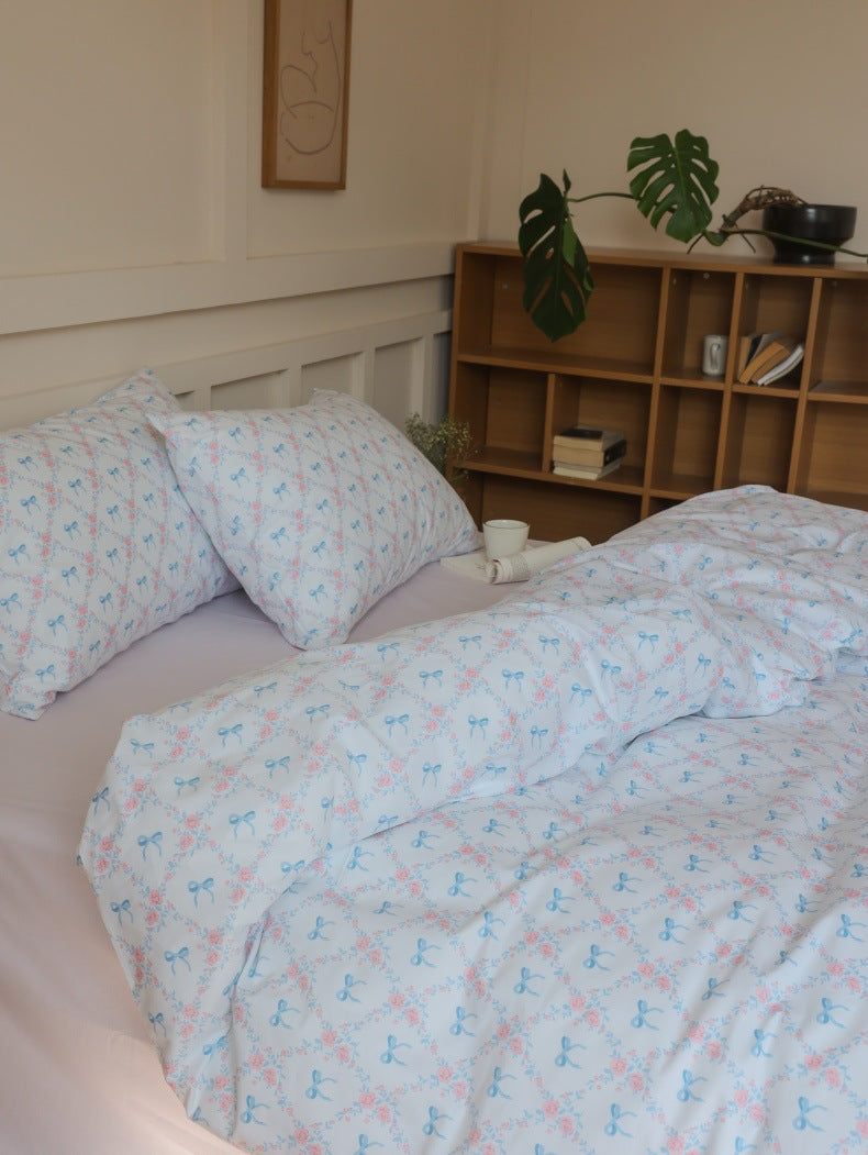 Ivory Blue Bow Rose Cotton Bedding Set – angled bed view showing the blue bow pattern - Roomden