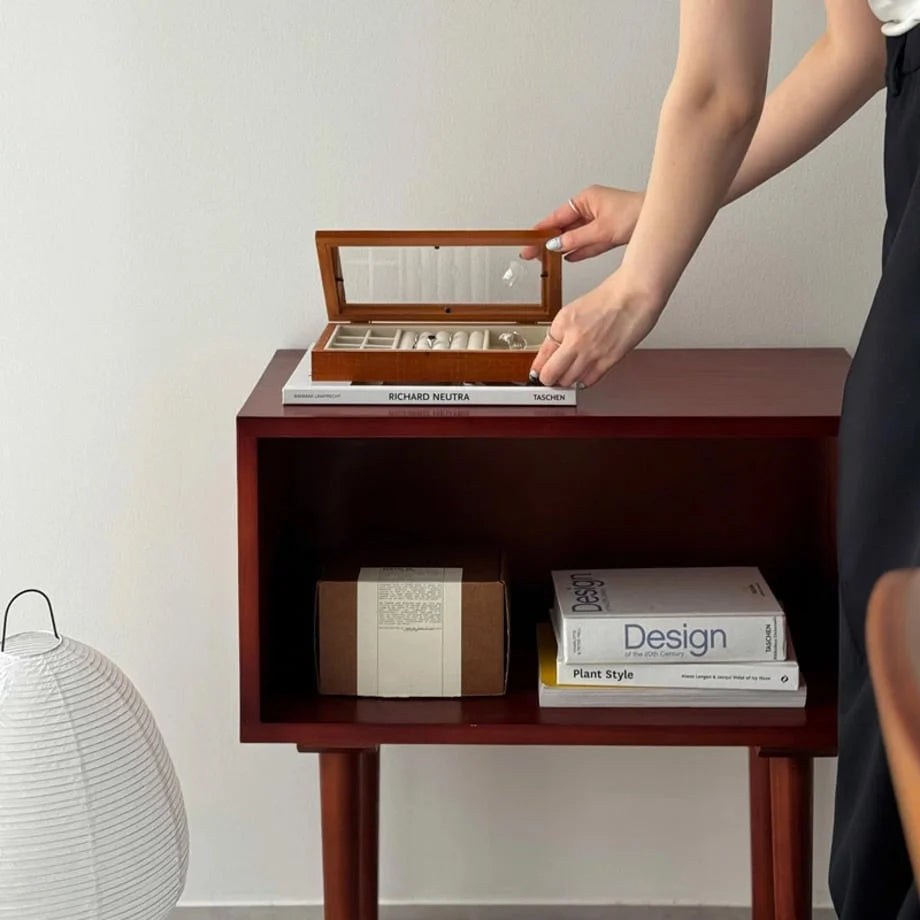 A person arranging their rings in the polished wood jewelry organizer on a console table. - RoomDen