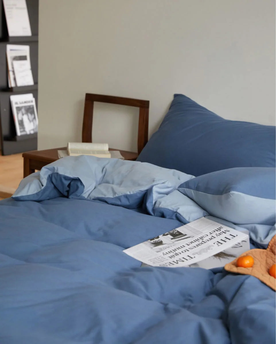 Cozy Bedroom Scene with Blue Jersey Cotton Bedding and Morning Light - RoomDen