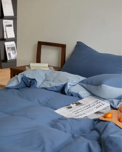 Cozy Bedroom Scene with Blue Jersey Cotton Bedding and Morning Light - RoomDen