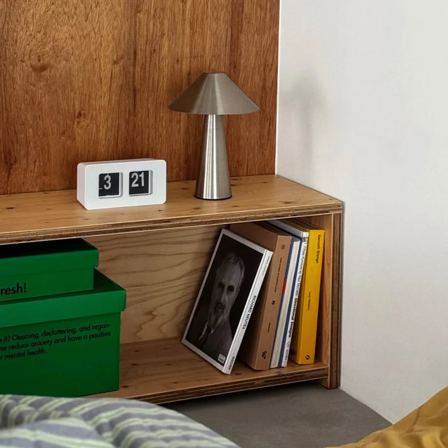 White retro flip clock on a light wood shelf next to a brushed metal lamp, showing 3:21. - RoomDen