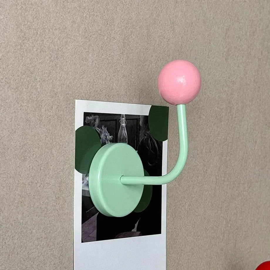 Pink & Mint Color Block Metal Hook used to hold a polaroid photo against a beige wall - RoomDen.