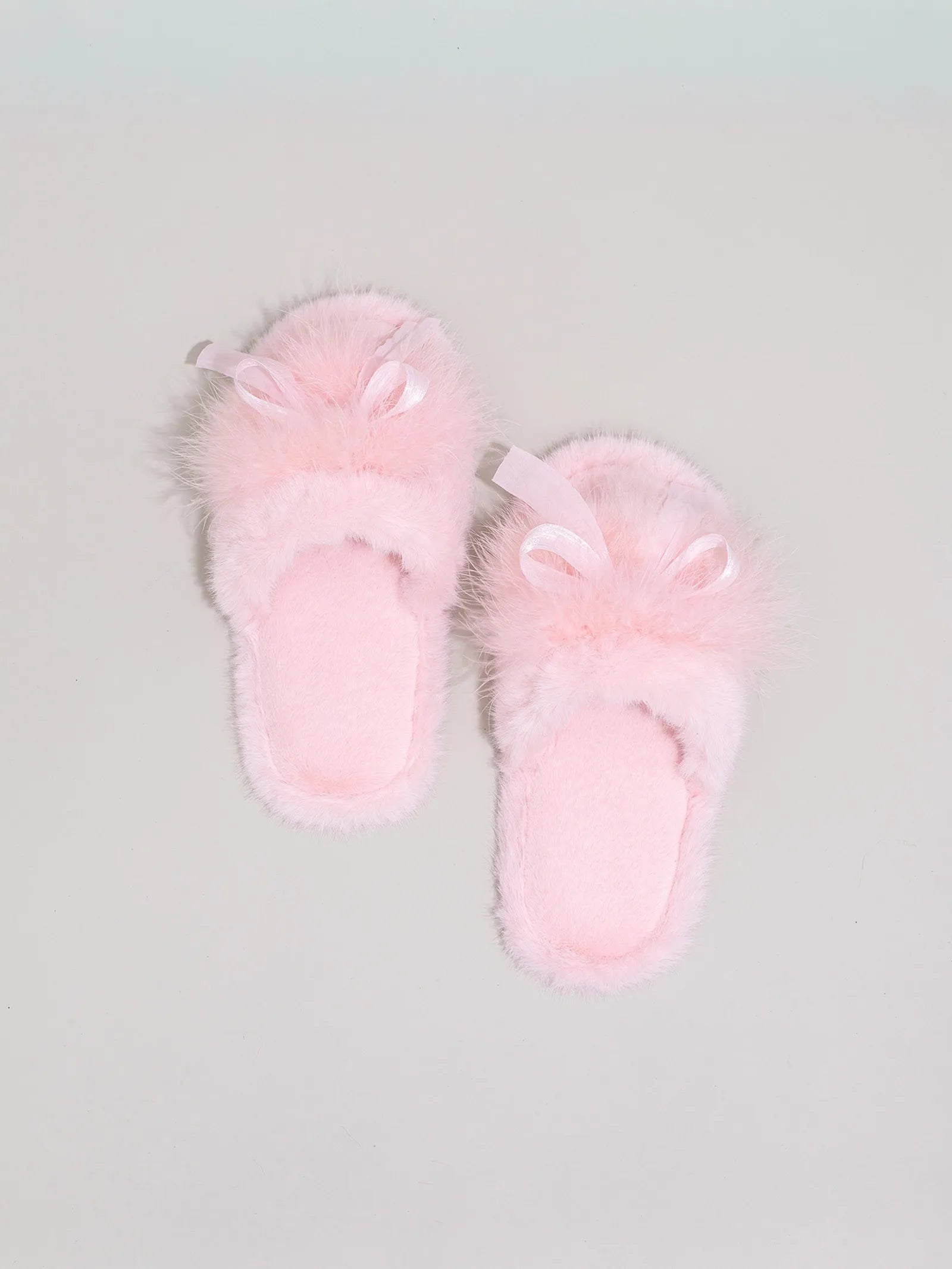 Pair of Baby Pink soft faux fur slides isolated on grey background