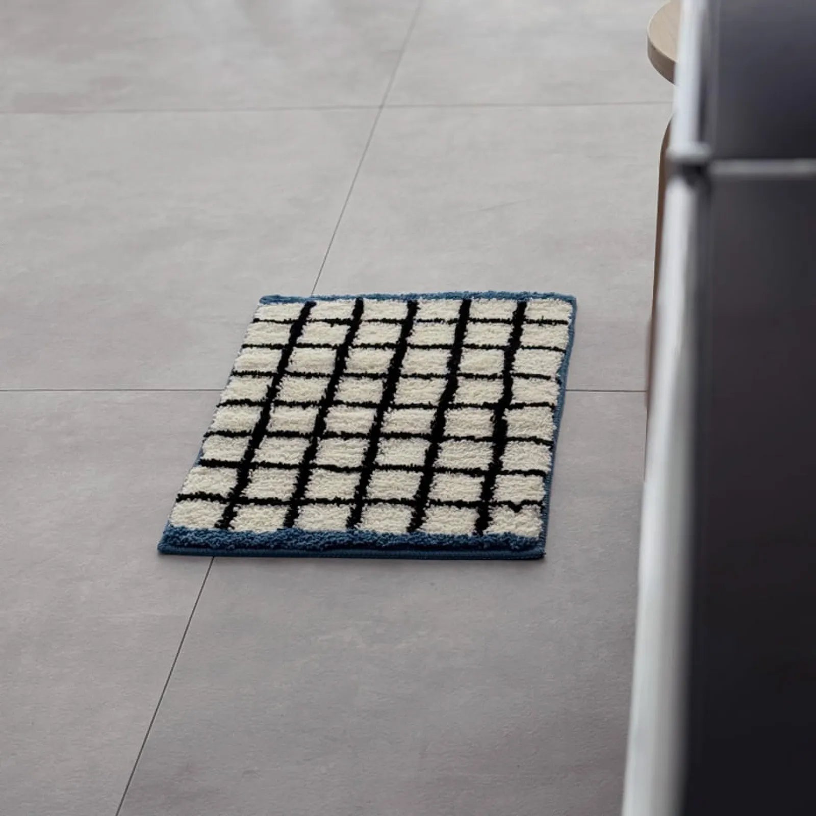 Full view of the rectangular plush grid rug featuring a black grid pattern and blue border - RoomDen