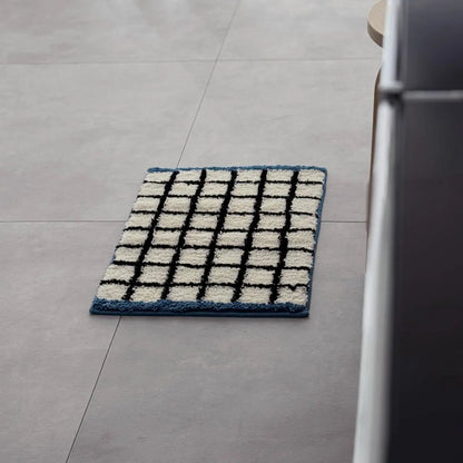 Full view of the rectangular plush grid rug featuring a black grid pattern and blue border - RoomDen