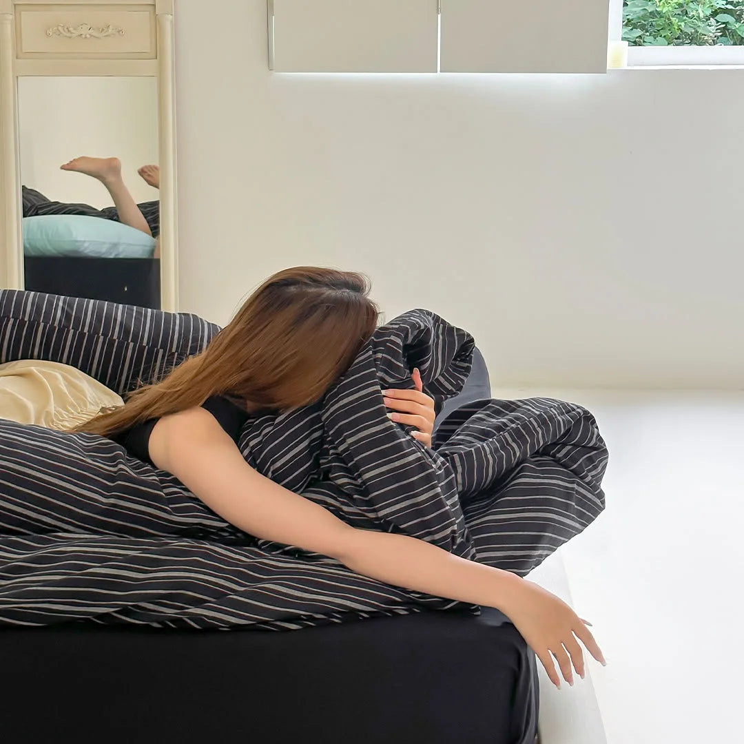 Lifestyle Shot of Girl Resting on Black Striped Bedding Set - RoomDen