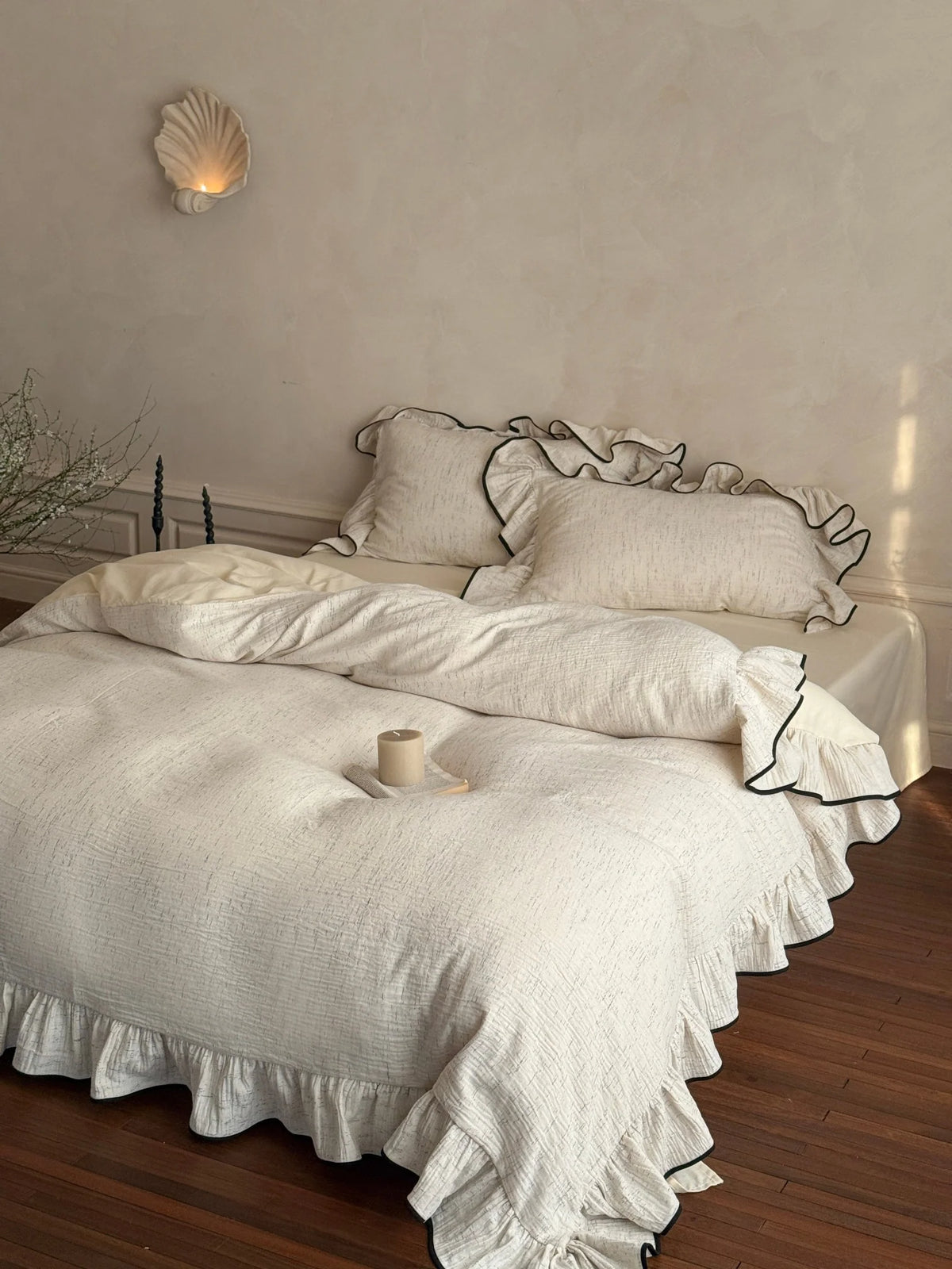 Black-piped ruffle double gauze bedding set – complete bed styled against a warm plaster wall - Roomden