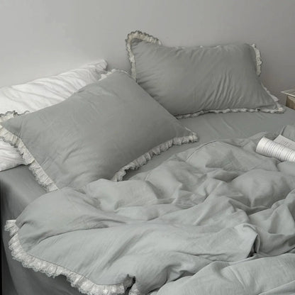 Sage green lace ruffle bedding set on a bed, with soft, natural lighting enhancing its cozy texture.