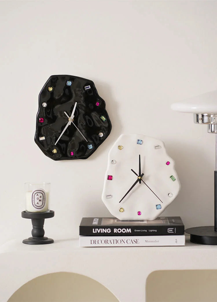 Wavy Jeweled Ceramic Clocks in black and white styled as wall decor above a stack of books - RoomDen