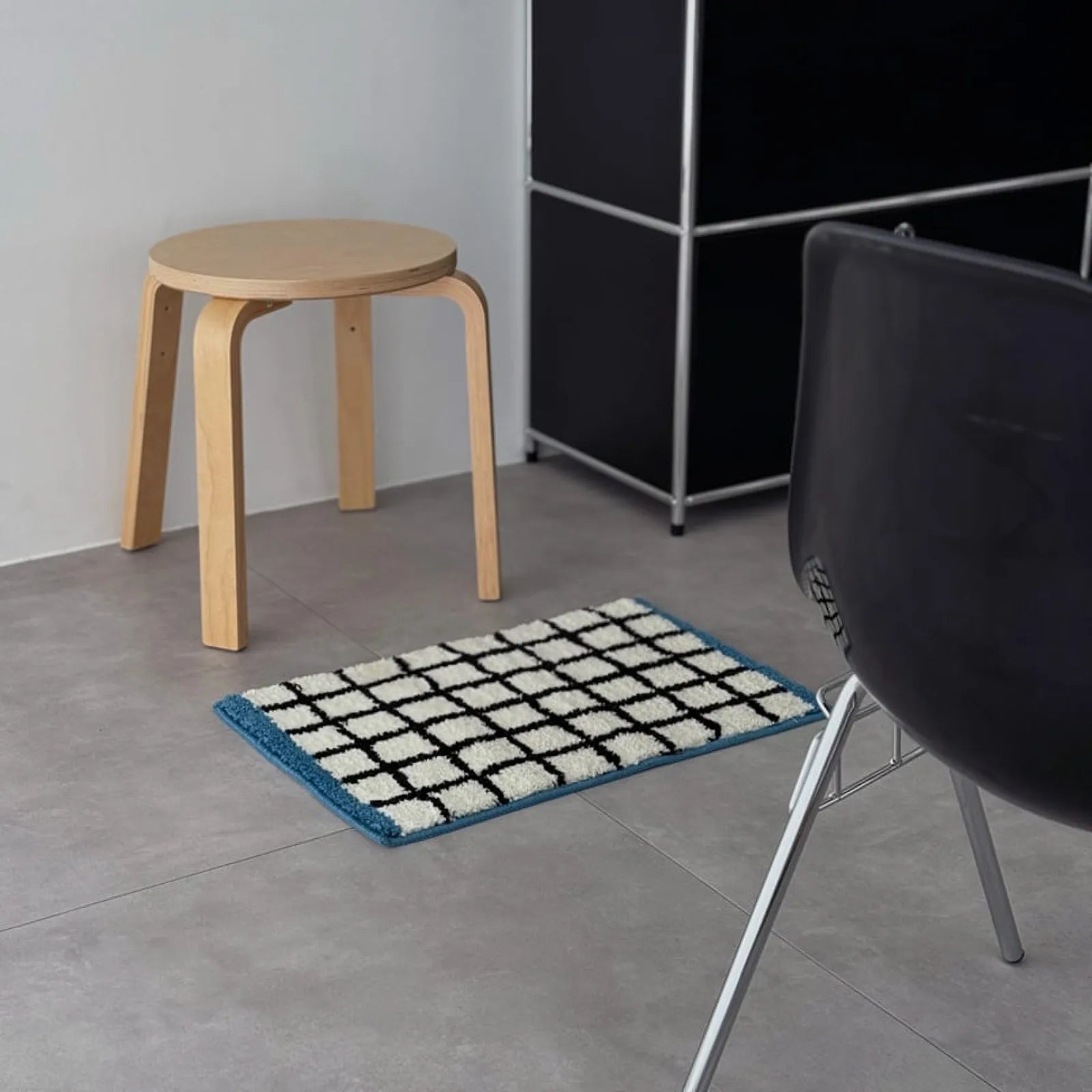 The checkered rug placed on the floor near a modern black storage unit - RoomDen