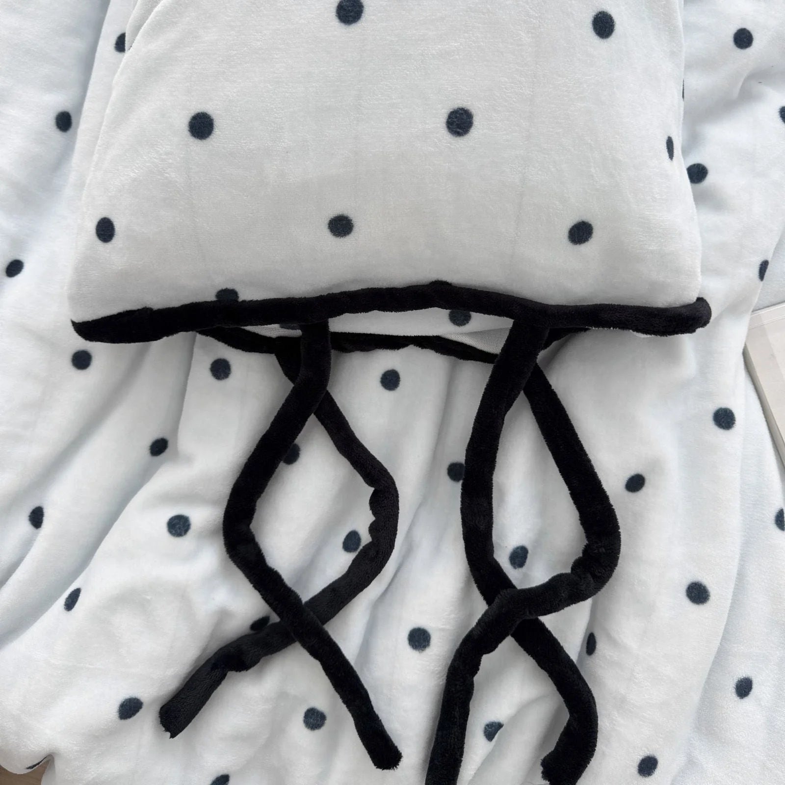 Close-up showing the black tie closures on the Light Blue Polka Dot Flannel Fleece pillowcase.