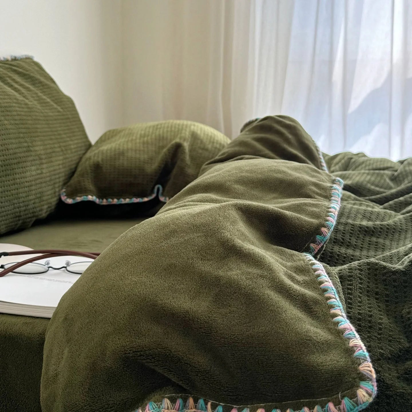 Detail shot focusing on the plush texture of the Olive Green flannel fleece duvet cover by a window.