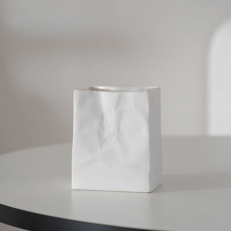 A single pure white crumpled ceramic organizer on a white table with soft lighting. - RoomDen