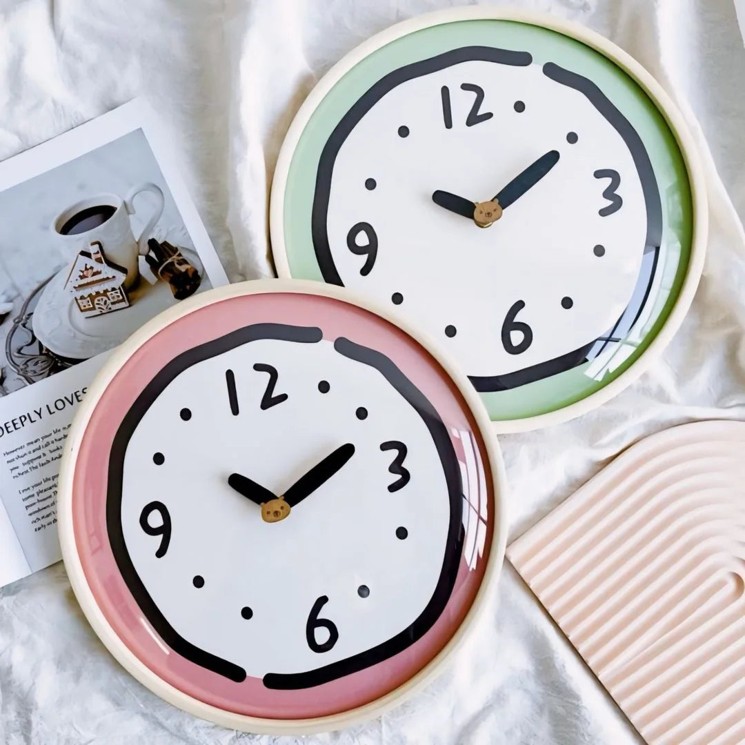 Whimsical Doodle Wall Clocks in pink and green on a white background - RoomDen.