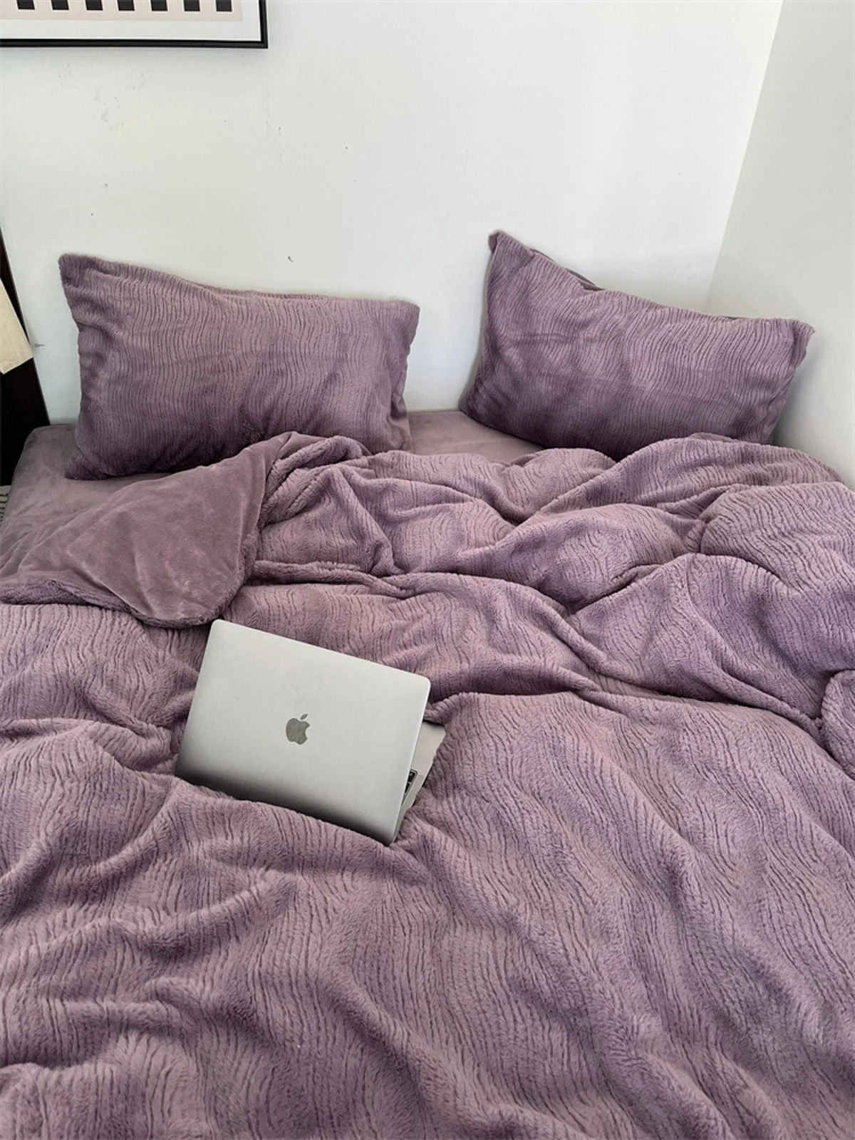 A laptop nestled into the plush folds of the Dusty Lavender ruched fleece duvet cover. - RoomDen