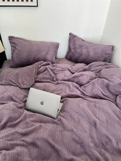 A laptop nestled into the plush folds of the Dusty Lavender ruched fleece duvet cover. - RoomDen