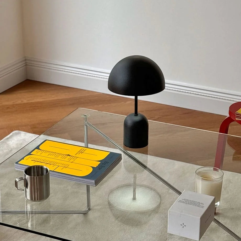 Matte Black mushroom accent lamp on a glass coffee table in a modern living room - RoomDen