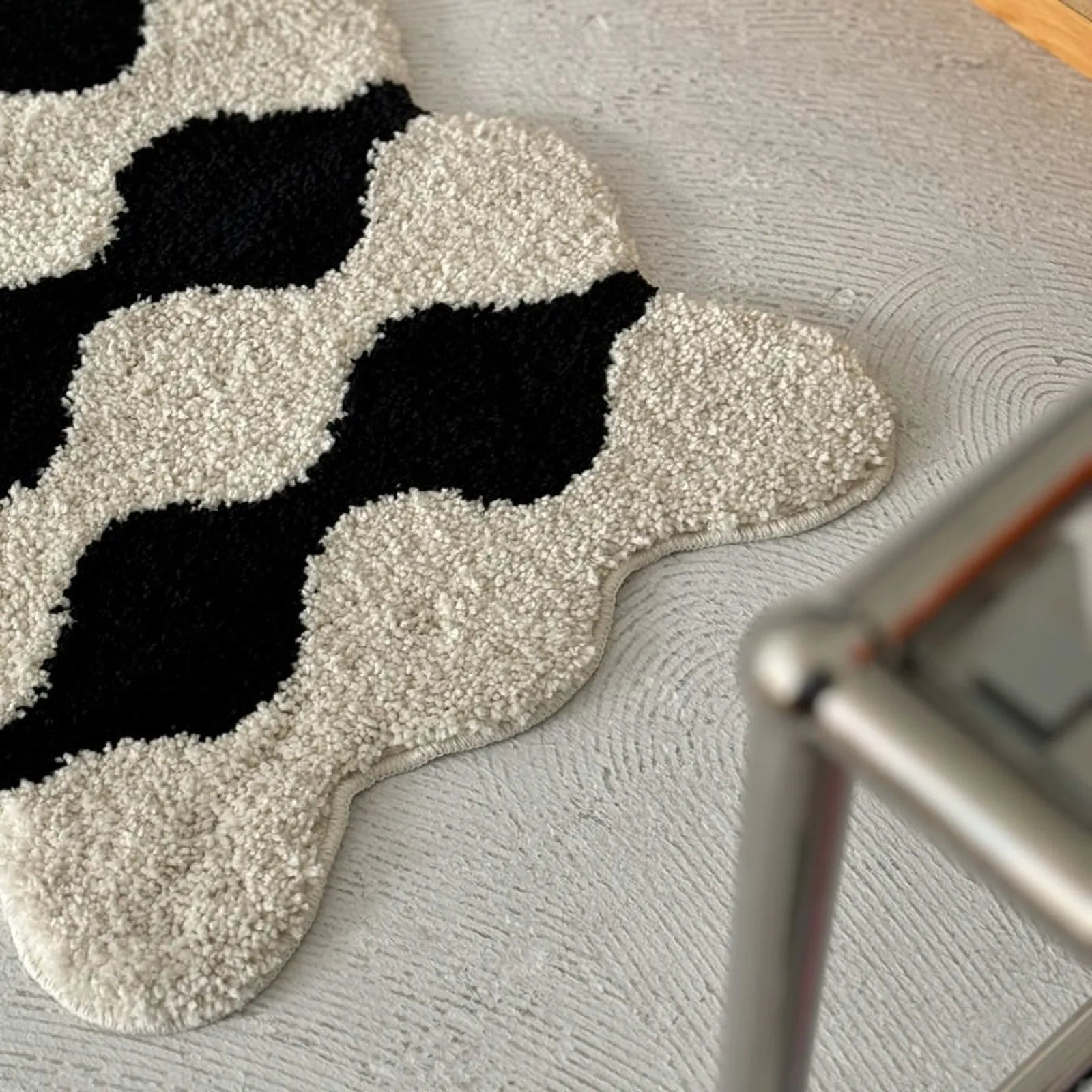 Detail shot of shaggy tufted texture on black and white wavy rug - RoomDen