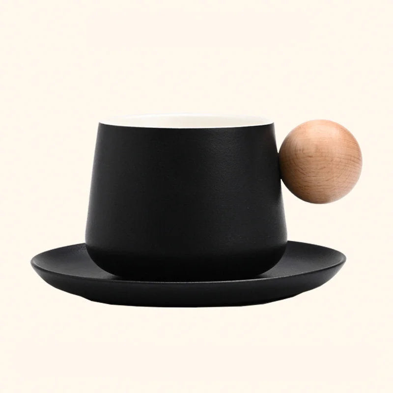 A studio shot of the Black Frosted Ceramic Mug and Saucer Set with a wooden ball handle. - RoomDen