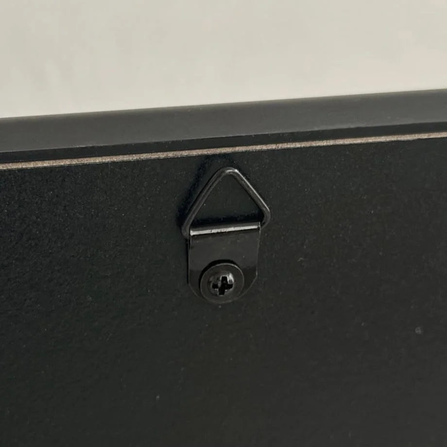 Close-up of the sawtooth hanger on the back of the black wall mirror. - RoomDen