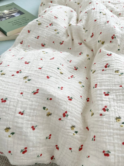 Close-up shot showing the soft, crinkled fabric and the whimsical cherry and bee pattern of the duvet cover. - RoomDen