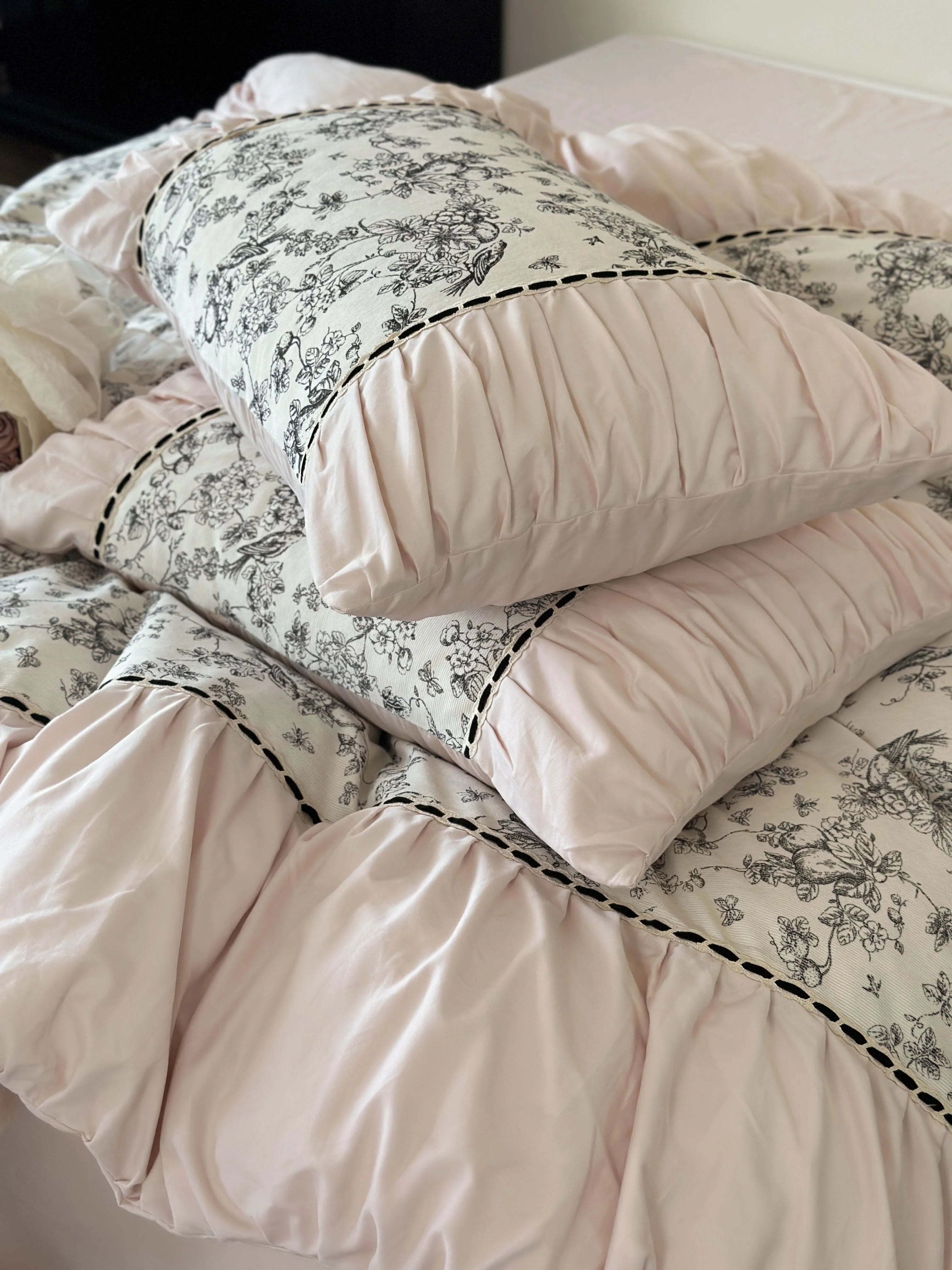 Detailed close-up of the ruched pillow shams of the Pink Toile bedding variant. - RoomDen