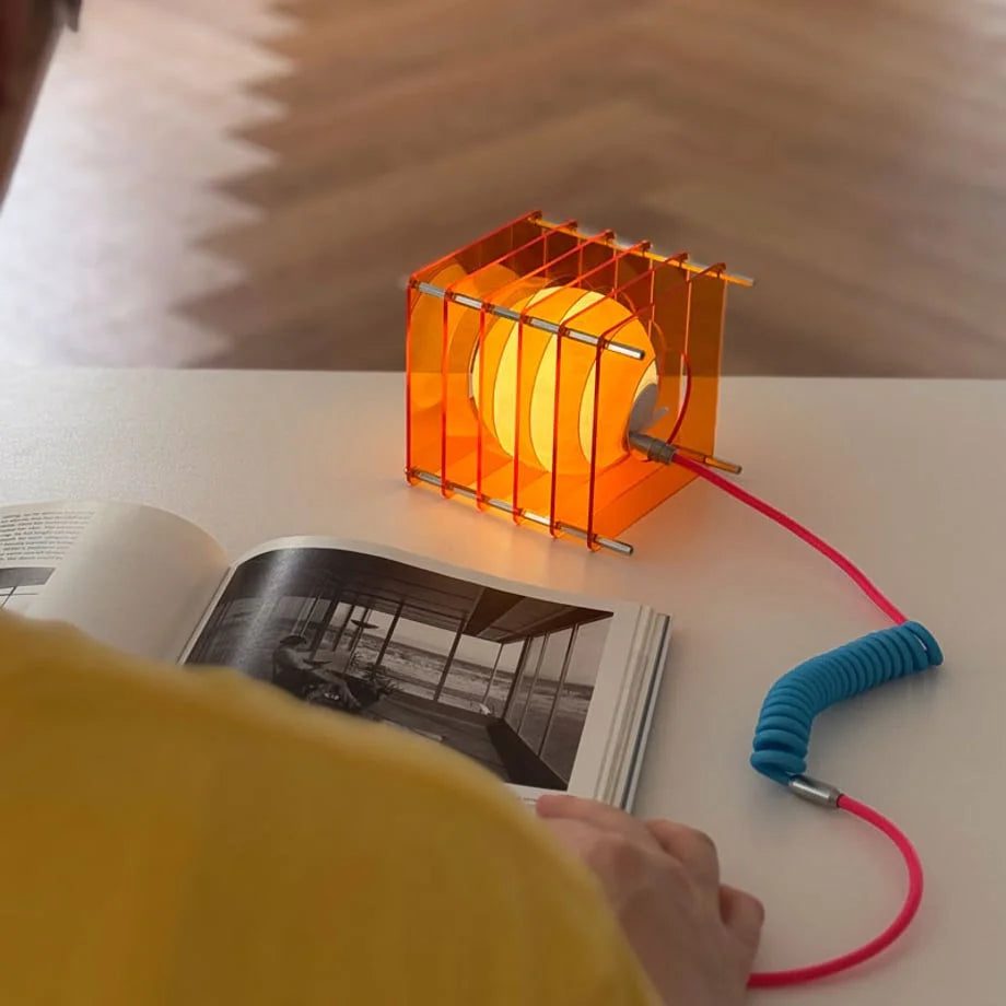 Textured Caged Resin Sphere Lamp in Sunset Orange on a white desk - RoomDen