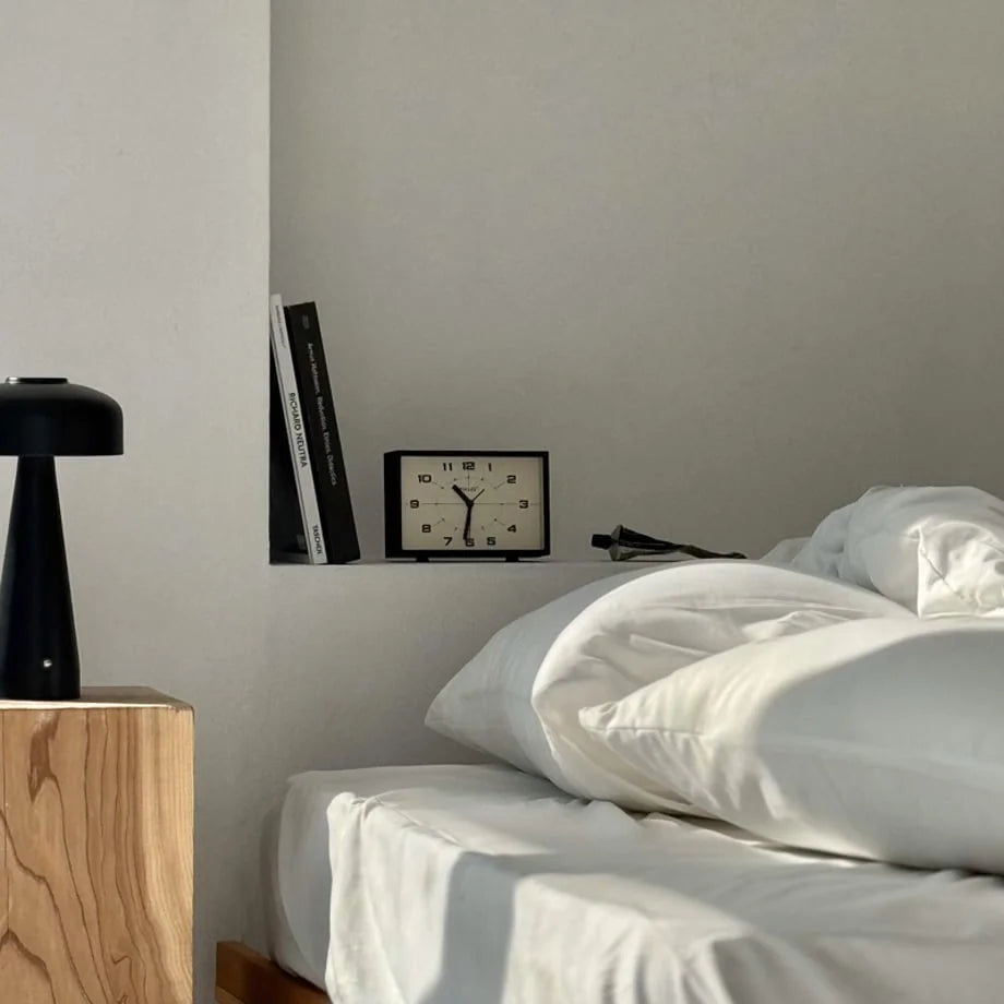 Matte Black Retro Analog Table Clock in a bedroom nook next to the bed - RoomDen.