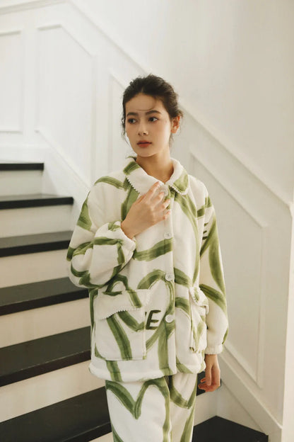 Model adjusting the scalloped Peter Pan collar of the green and white graffiti print fleece pajama top - RoomDen.