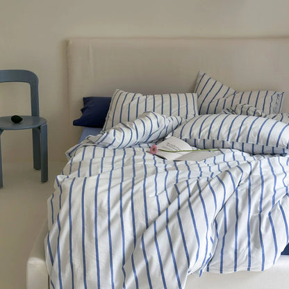 Blue Striped Pillowcase and Duvet Cover on Bed with Blue Chair - RoomDen