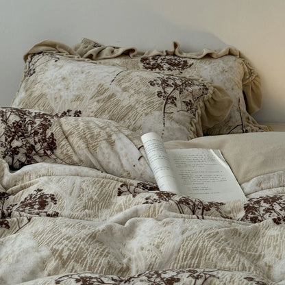 A detailed view of the ruffled pillowcase and duvet cover from the floral branch washed cotton bedding set, highlighting the vintage-inspired design.