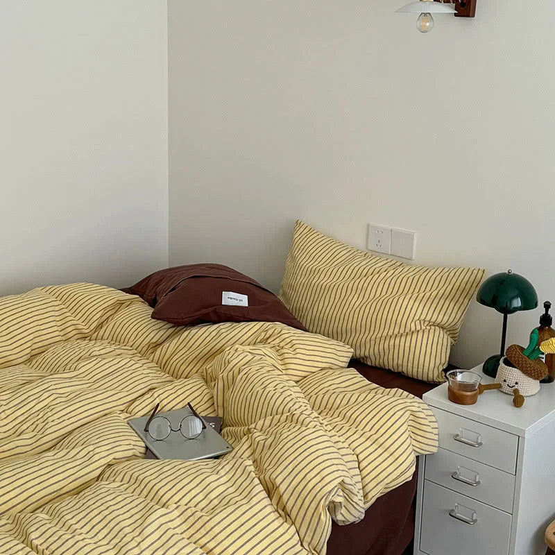 Corner view of a bedroom with the Yellow & Brown Striped Washed Cotton Bedding, creating a warm and inviting atmosphere - RoomDen.
