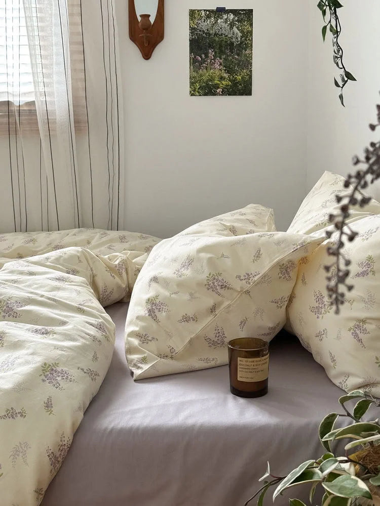 The wisteria floral bedding set seen from the side, with a candle and plants adding to the serene vibe - RoomDen.