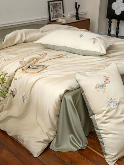 Angled shot of the beige duvet cover with butterfly embroidery, showing the sage green sheet underneath - RoomDen