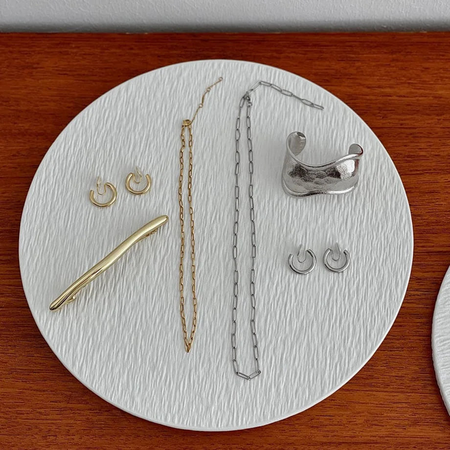 Top-down detail view of the large white textured ceramic jewelry organizer displaying a curated collection of pieces. - RoomDen