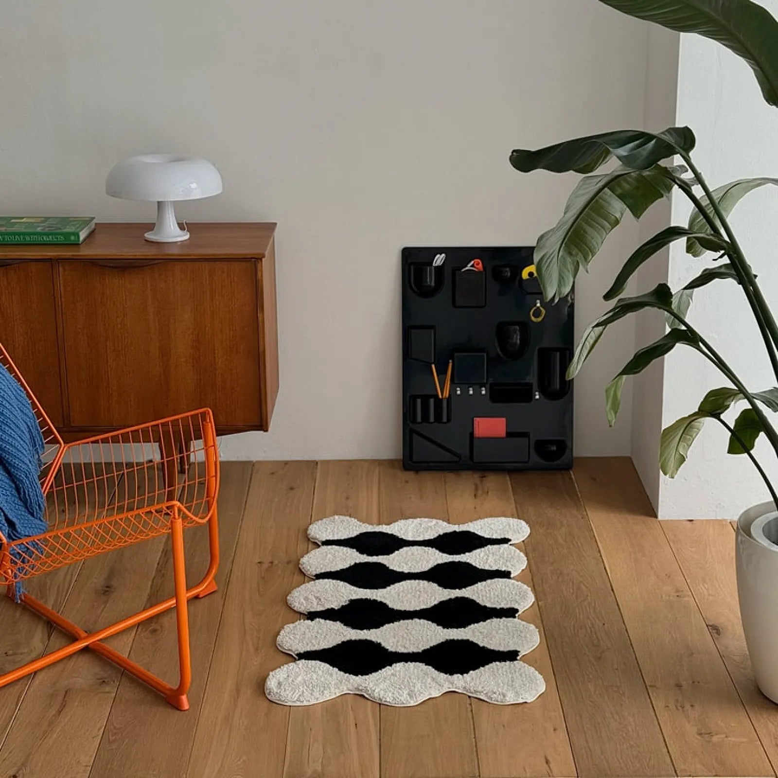 Black and white wavy rug placed beside a low platform bed - RoomDen