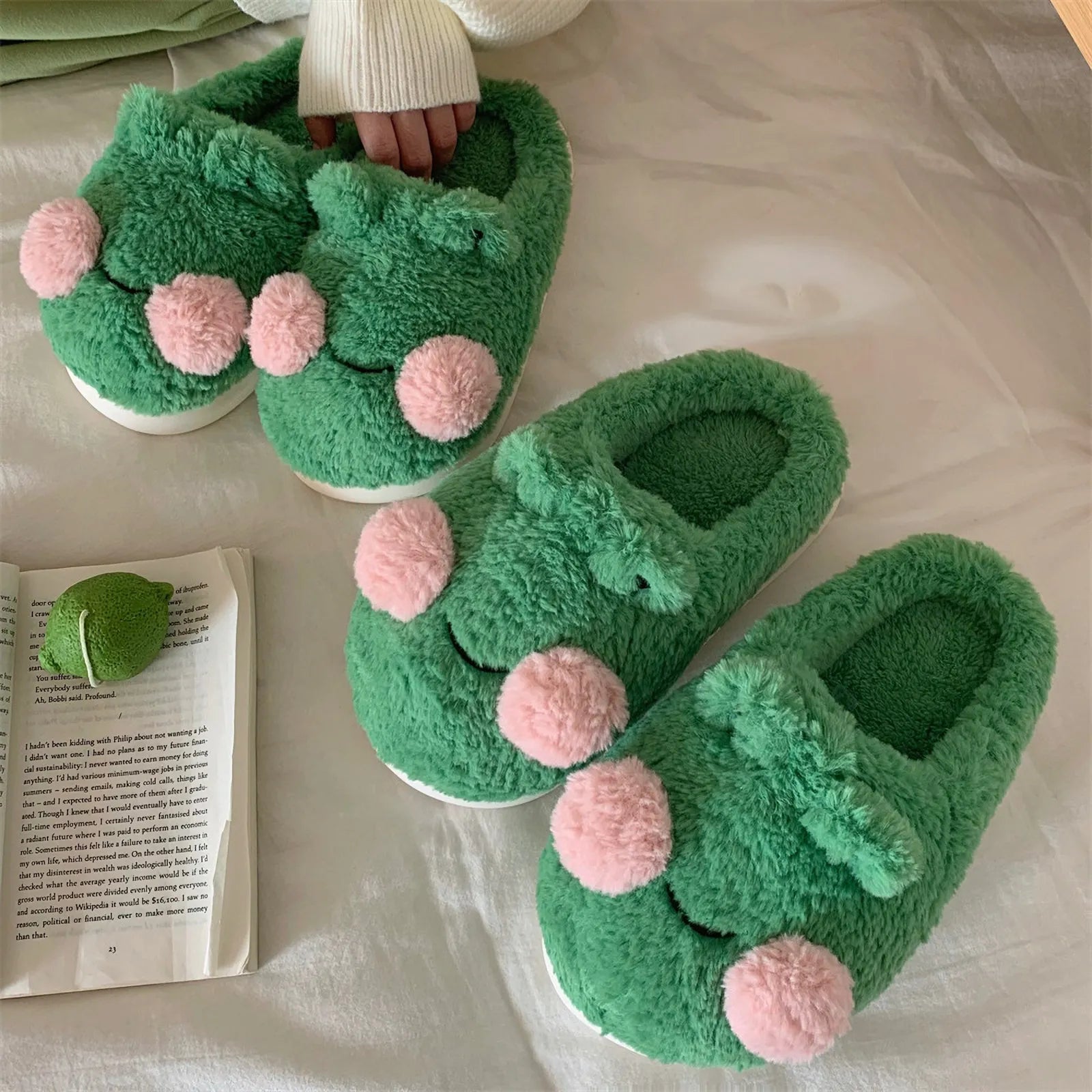 Multiple pairs of green frog fleece slippers displaying cozy texture - RoomDen