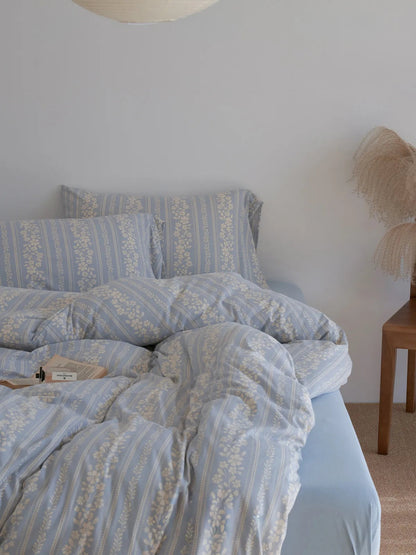 Soft Floral Stripe Washed Cotton Bedding Set in cornflower blue, styled on a bed in a bright, minimalist room. - RoomDen