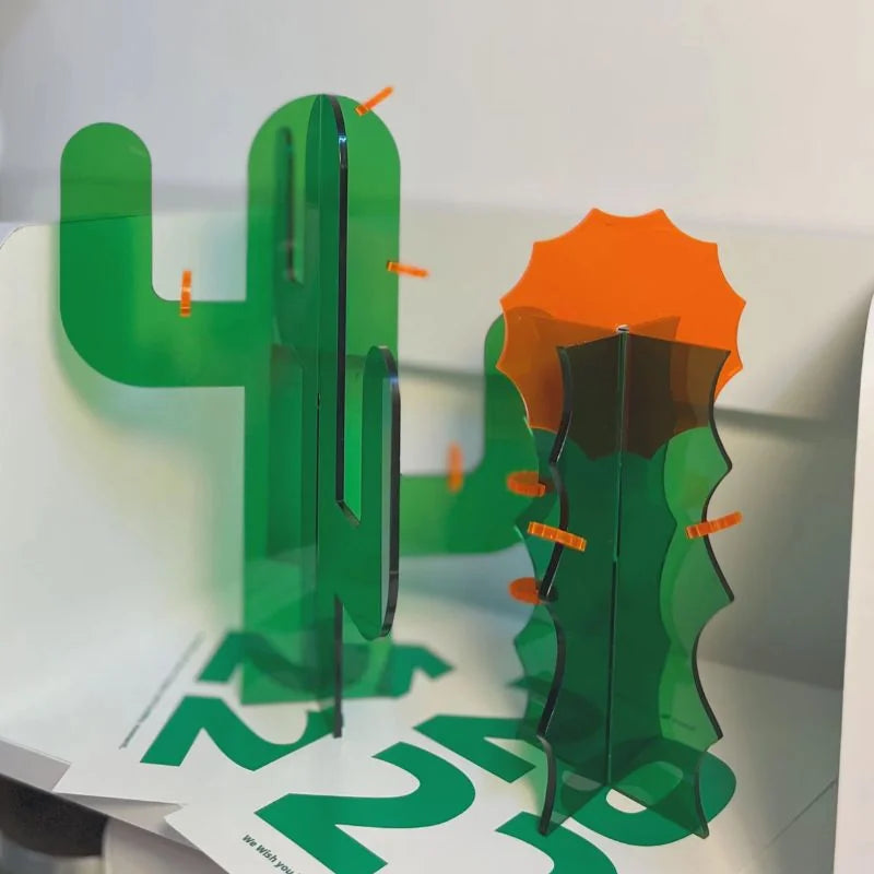 Detail shot of two acrylic cactus figurines, highlighting the interlocking design and bright orange accents - RoomDen