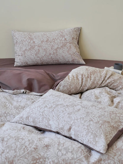 Angled view of the bed with the vintage botanical bedding set, showing the pillow arrangement and the rumpled, inviting texture of the duvet. - RoomDen