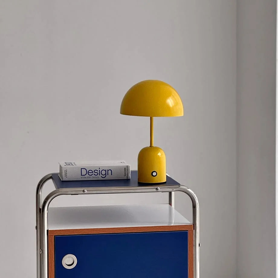 Lifestyle image of the Canary Yellow mushroom lamp sitting on a modern blue and white nightstand - RoomDen