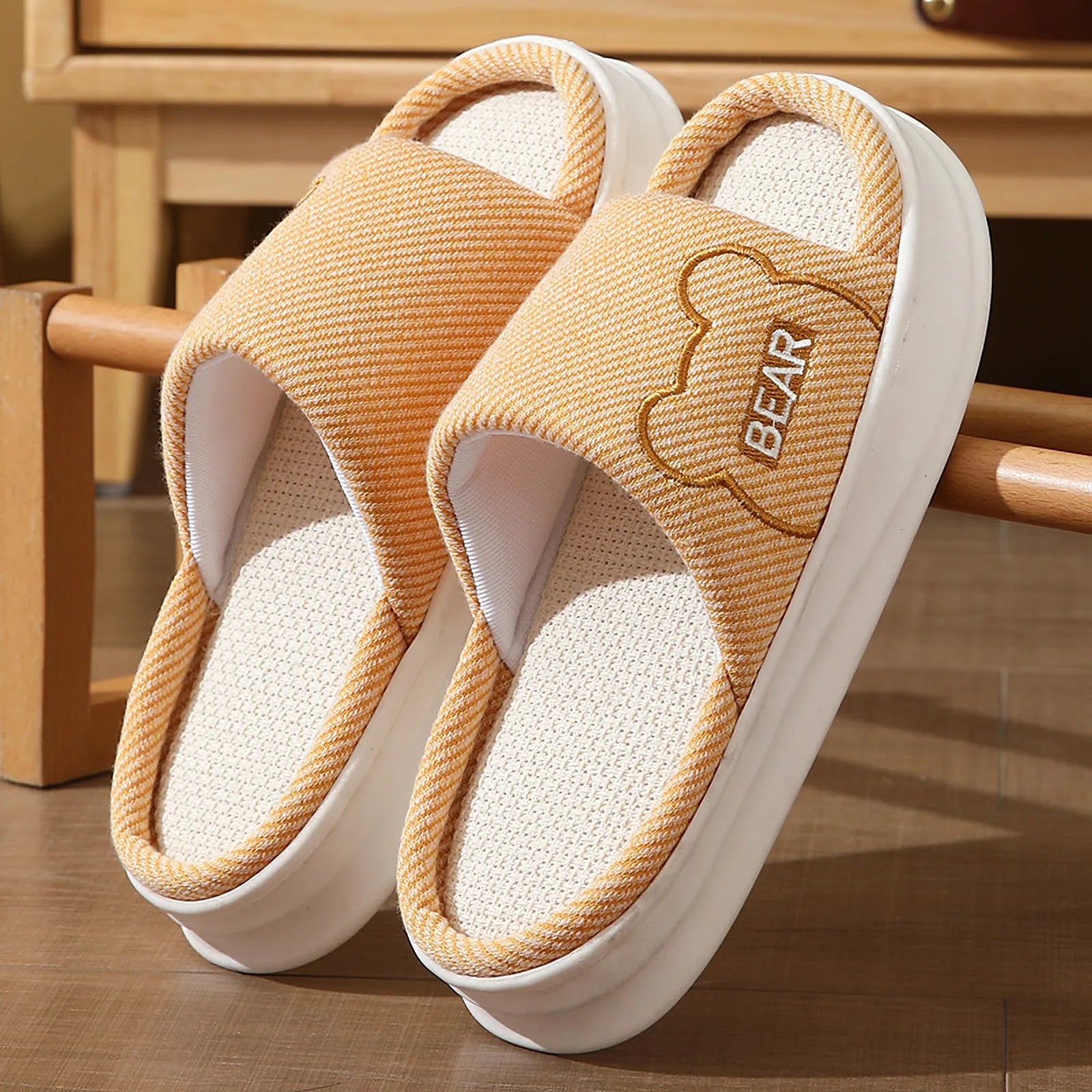 Detailed view of Orange linen house slippers with cute bear motif