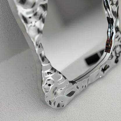 Macro shot focusing on the liquid-like texture and reflections on the mirror's chrome frame - RoomDen