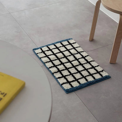 Isolated view of the White & Blue Checkered Tufted Accent Rug on a neutral floor - RoomDen