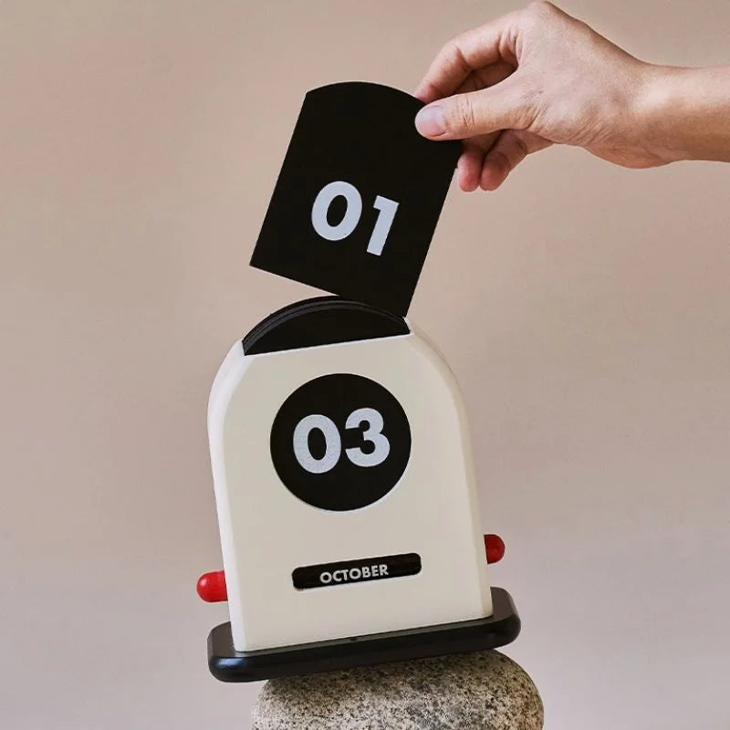 Hand flipping the date card on a Retro Wooden Perpetual Desk Calendar - RoomDen