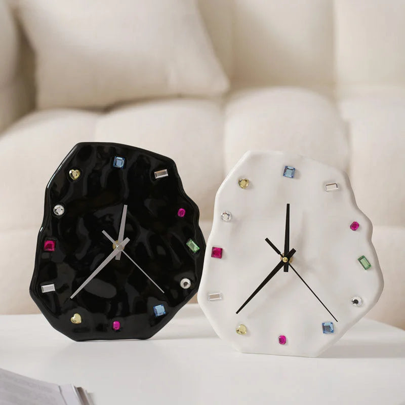 The Wavy Jeweled Ceramic Clocks in both black and white shown side-by-side on a white desk - RoomDen
